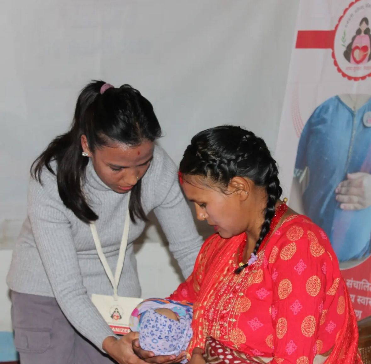A health worker guiding a mother through newborn care